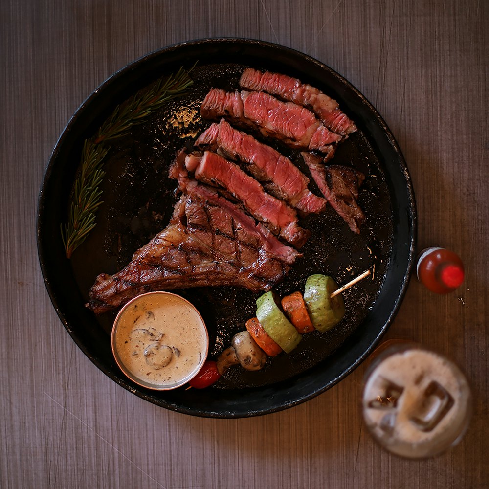 Tabla de carne cortada en fetas con verduras grilladas
